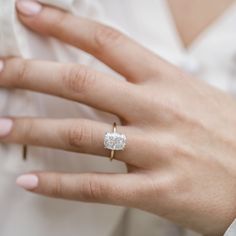 a woman's hand with a ring on it and a diamond in the middle