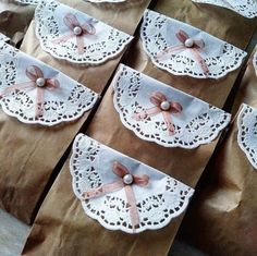 some brown paper bags with lace and bows on them