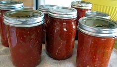 six jars of tomato sauce sitting on a table