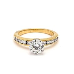 a yellow gold engagement ring with diamonds on the band and a single stone in the center