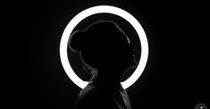 a woman standing in front of a circular light with her head turned to the side