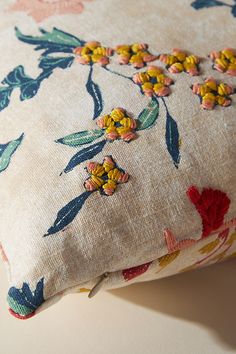 a pillow with flowers on it sitting on a table