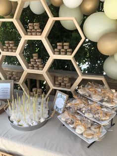 dessert table with honeycombs, marshmallow sticks and other treats on it