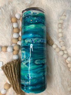 a blue and white vase sitting on top of a fur rug next to some beads