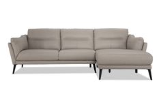 a gray leather sectional sofa sitting on top of a white floor