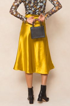 Say hello to the Tiff Skirt in Chartreuse - the perfect combination of style and comfort! This midi-length skirt made from yellow satin fabric is not only elegant but also easy to slip on. And with its stretchy material, you'll never want to take it off. A must-have for any fashion-forward wardrobe. Flowy Satin Skirt For Fall, Chic Satin Skirt For Fall, Fall Silk Midi Skirt, Silk Midi Skirt For Fall, Gold Chic Midi Skirt, Chic Gold Midi Skirt, Gold Satin Party Skirt, Gold Relaxed Skirt Bottoms For Spring, Chic Gold Skirt For Spring