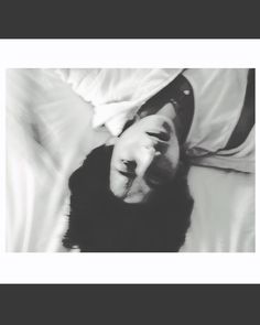 a black and white photo of a person laying in bed