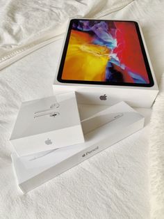 an apple ipad pro is sitting in its box on the bed with it's lid open