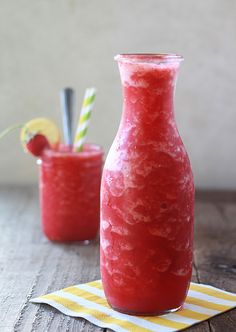 two glasses filled with red liquid sitting next to each other