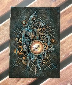 an intricately decorated card on a wooden surface with gears and cogs in the center