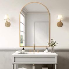 a white sink sitting under a mirror next to a wall mounted faucet in a bathroom