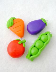 three peas, two carrots and one eggplant are on a white surface