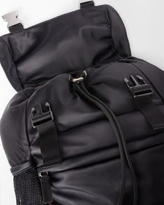 the back side of a black backpack with straps and zippers on it's sides