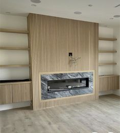 an empty room with shelves and a fireplace