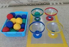 plastic balls and cups are sitting on the floor next to a basket full of them