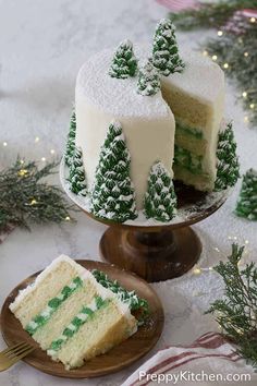 two pieces of cake with green frosting and trees on the top are sitting on plates