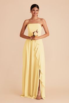 a woman in a strapless yellow bridesmaid dress standing with her hands on her hips