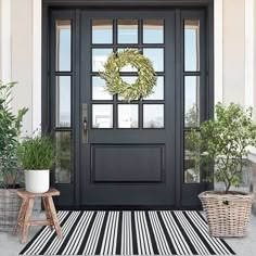 a black and white striped rug with a wreath on the front door