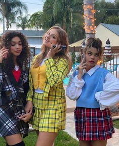 three young women standing next to each other talking on cell phones