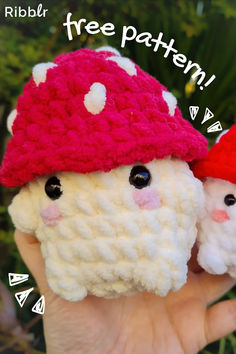 two small crocheted gnomes with hats on their heads, one is white and the other is red