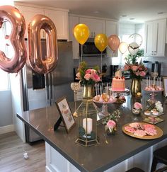 a kitchen counter topped with lots of food and balloons in the shape of number 90