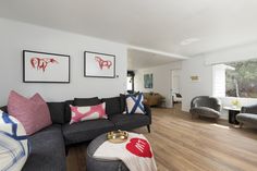 a living room filled with furniture and pictures on the wall