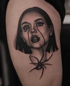 a woman's face with a spider on her thigh