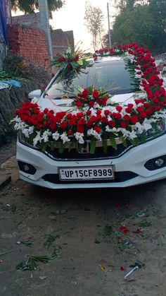 a white car with red and white flowers on the hood