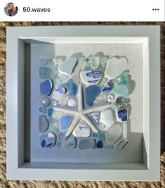 a white frame with blue and white sea glass in the shape of a starfish