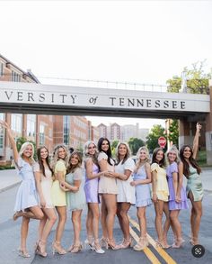 a group of young women standing next to each other in front of a sign that says university of tennessee