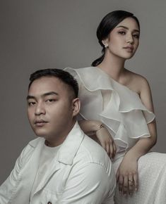 a man sitting next to a woman in a white dress