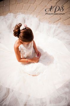 a woman in a wedding dress sitting on the ground