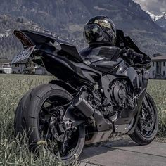 a black motorcycle parked on the side of a road in front of a mountain range