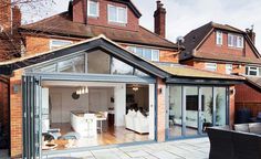 an open living room and dining area in a house with glass doors on the outside