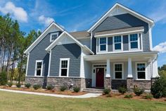 a house with gray siding and white trim on the front door, windows, and shutters