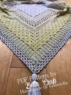 a crocheted shawl with tassels on it