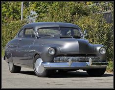 an old car is parked on the street