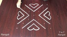 a person standing on top of a wooden table next to a cross and hearts drawn in chalk