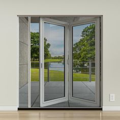 an open glass door with the reflection of trees and water in it's windows