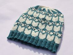 a blue and white knitted beanie with hearts on it