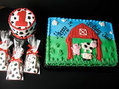 a birthday cake and some candy bags on a black table with a farm scene design