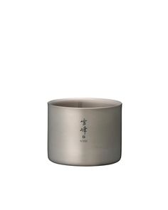 a stainless steel bowl with chinese writing on the front and bottom, sitting on a white surface