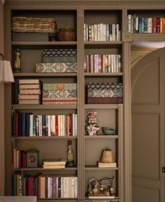 a bookshelf filled with lots of books next to a doorway