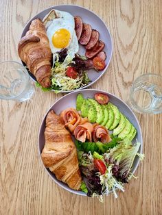 two plates filled with food on top of a wooden table