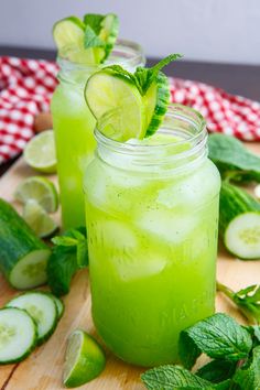 two mason jars filled with cucumber and limeade on top of a cutting board