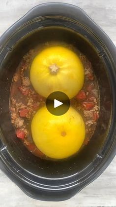 two yellow tomatoes are in the bottom of an instant pot with water and food inside