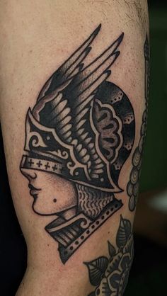 a black and white tattoo on the arm of a man with a helmet in it