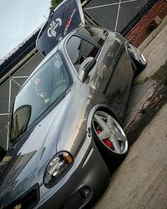 a silver sports car parked next to a building