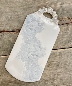 a white ceramic vase sitting on top of a wooden table next to a piece of wood