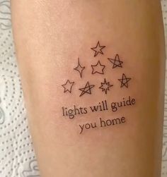 a tattoo saying lights will guide you home on someone's leg with five stars